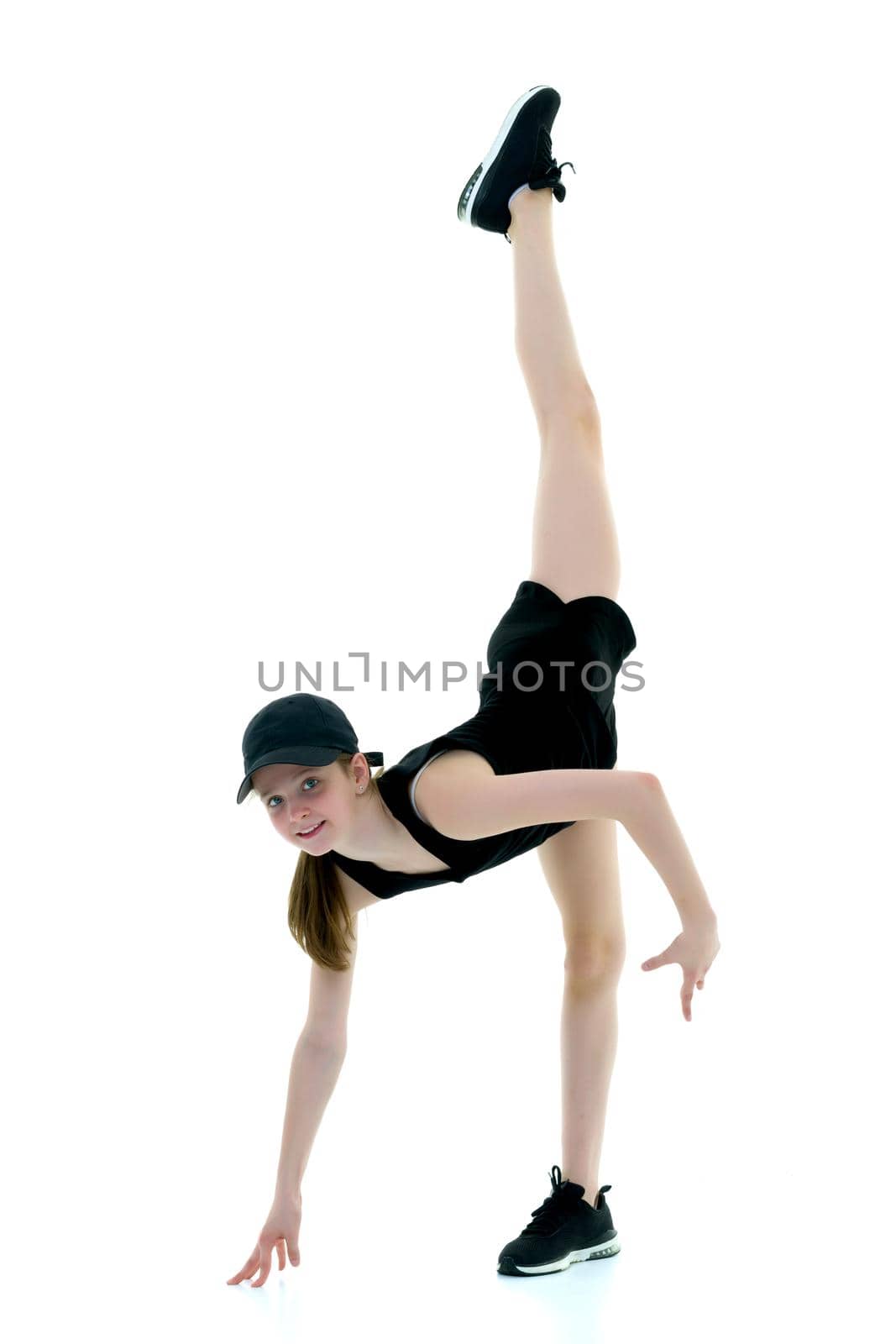 A teenage girl is engaged in fitness. She performs various exercises. The concept of childhood, sport, a healthy lifestyle. Isolated on white background.