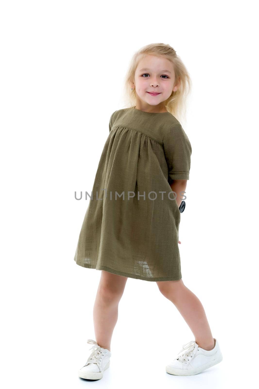 Charming little girl in a light summer dress. Concept of family vacation, happy childhood. In isolation.