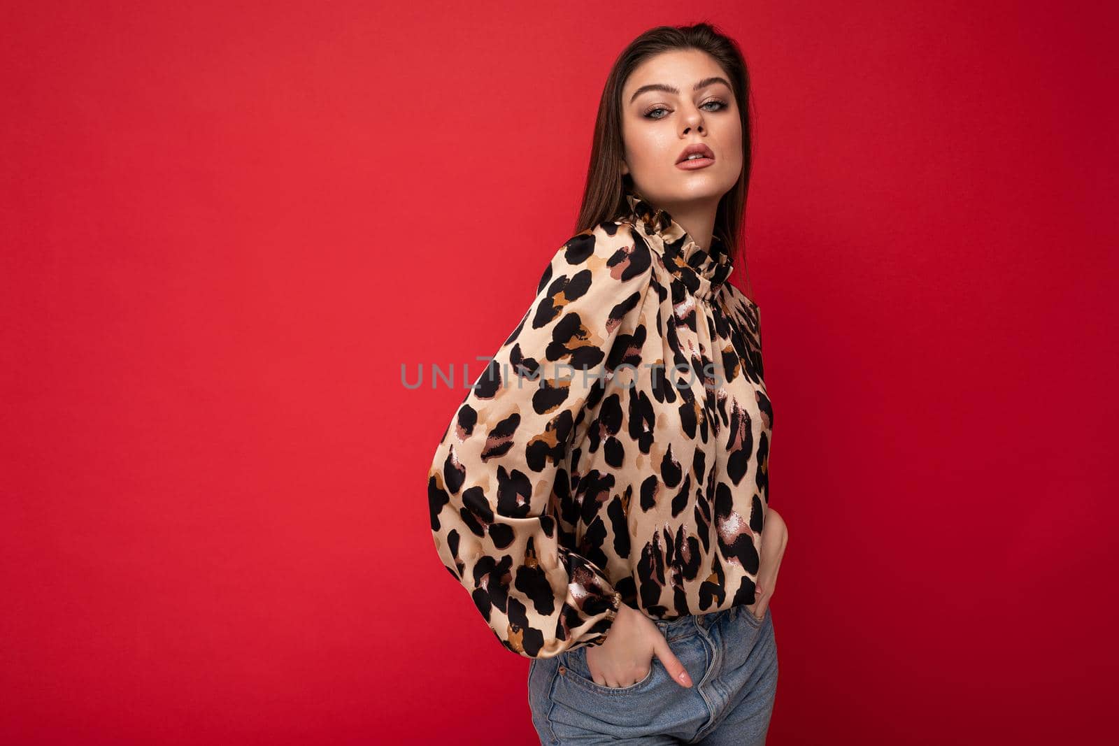 Close-up portrait of young nice-looking attractive lovely glamorous brunet woman wearing leopard blouse isolated on red color background with free space.