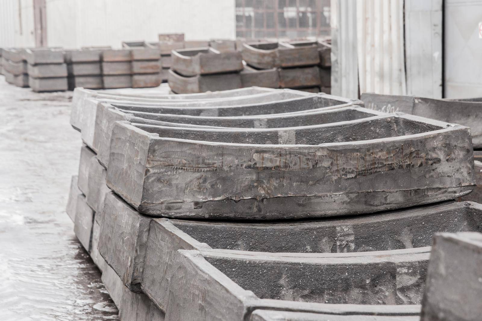 Cast iron tubing reinforced concrete cast products for lining distillation tunnels and underground structures are stored in the warehouse of the industrial plant by AYDO8