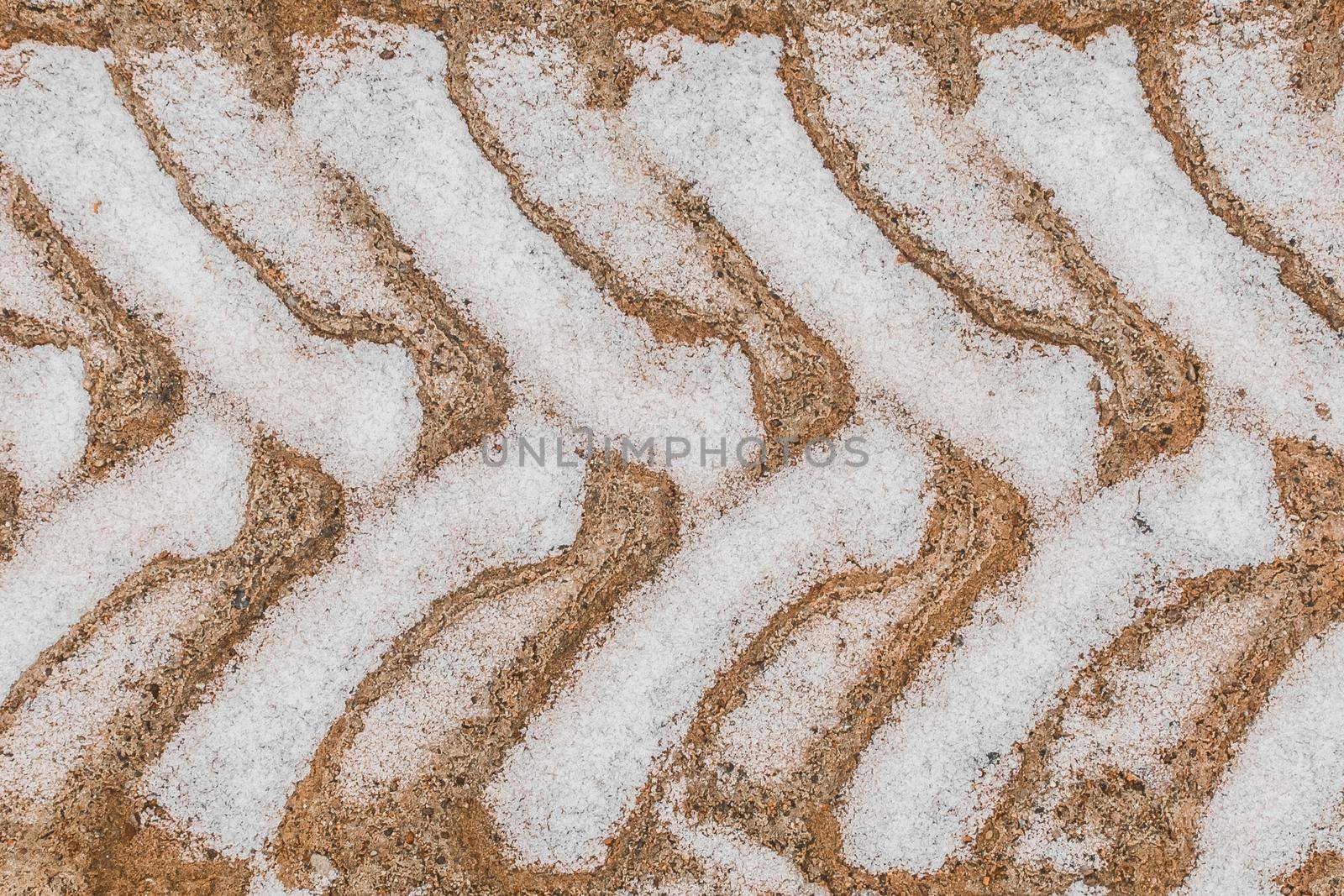 Traces and patterns from the tires of the wheels of industrial transport on the ground in winter background.