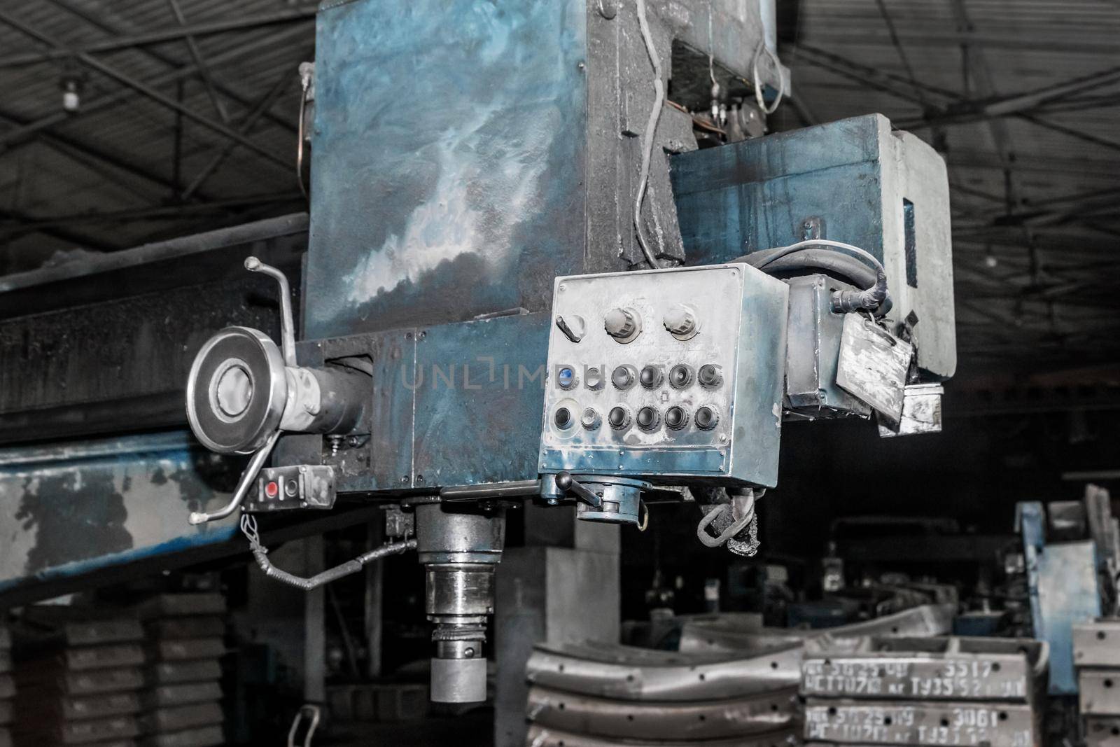 Old milling machine tool with control panel and buttons and equipment for metalworking in the workshop of an industrial plant.