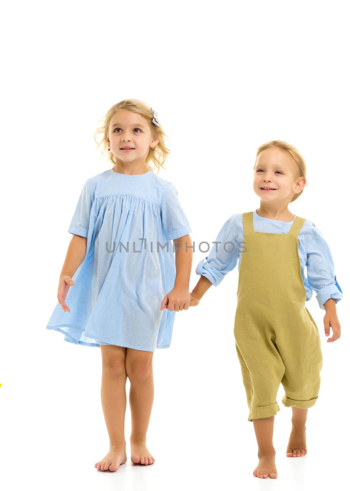 A boy and a girl are holding hands. The concept of friendship, happy childhood. Isolated on white background.