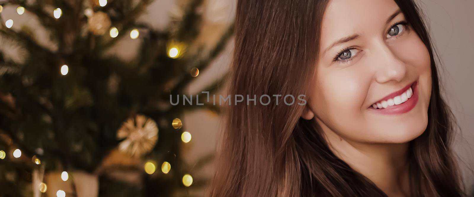 Christmas time and holiday mood concept. Happy smiling woman and decorated xmas tree lights on background by Anneleven