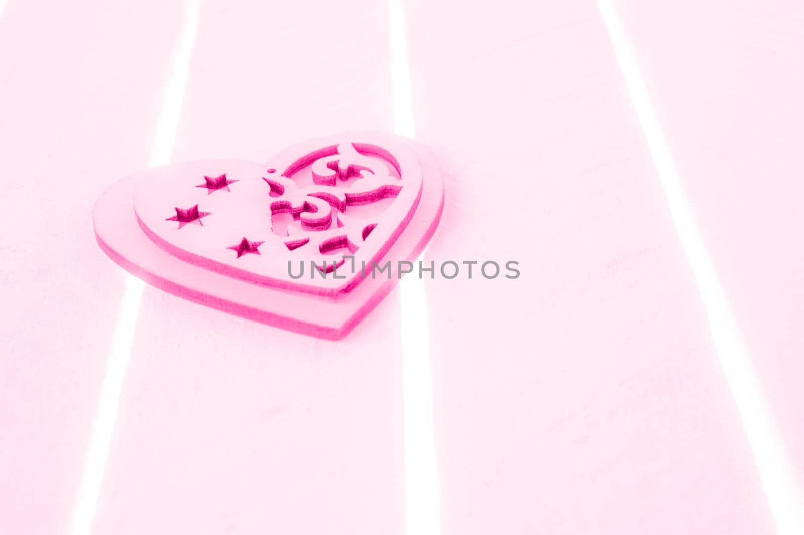 Pink heart on a white wood background - love and valentines day concept. Toned. Copy space.