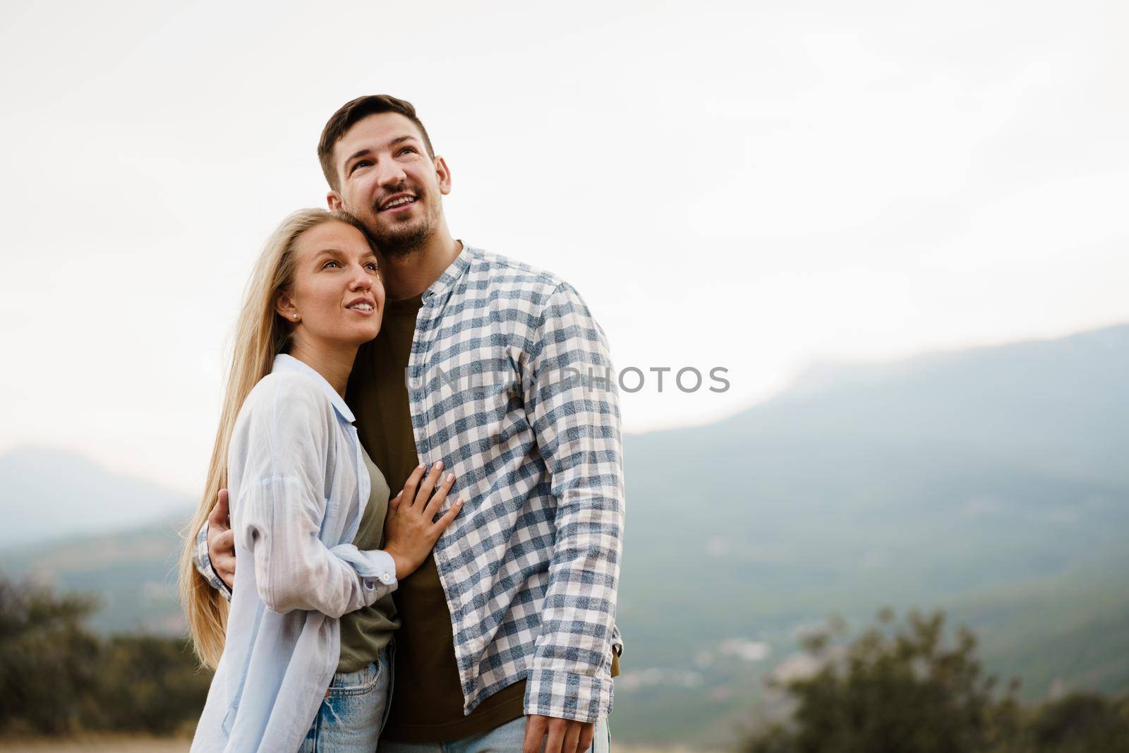 Happy loving couple hiking and hugging in mountains, close up