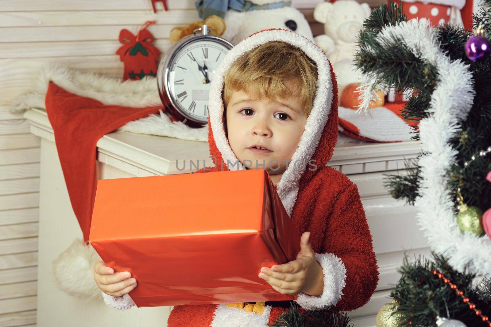 Christmas happy child boy with gift box. Santa kid on Christmas tree. Winter kids holiday by Tverdokhlib