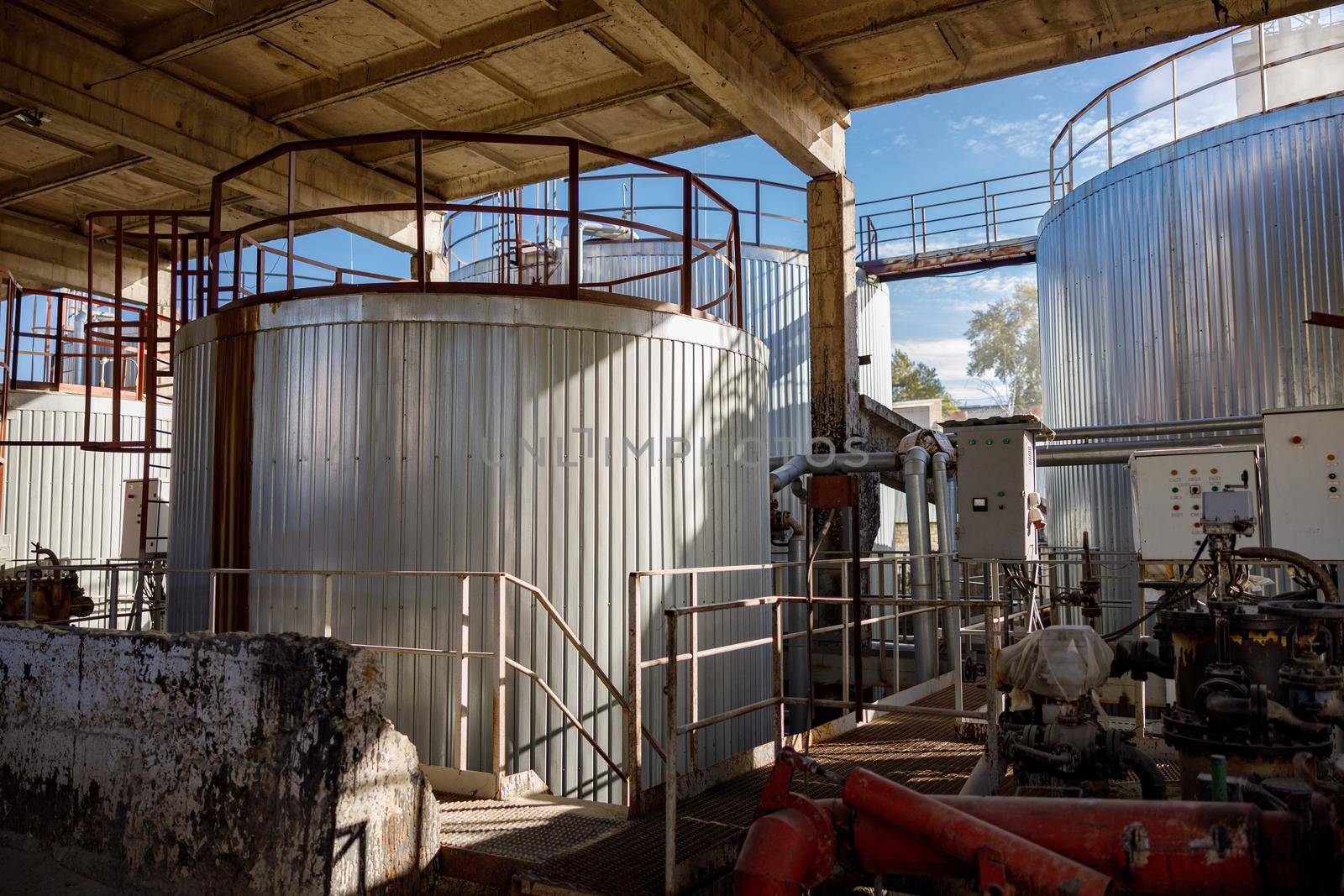 Section of manufacturing production plant with pipes and industrial metal containers