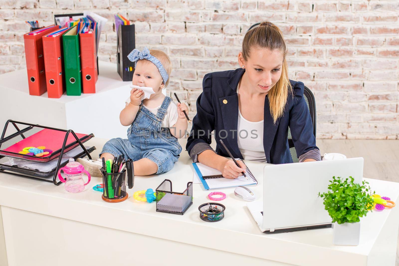 Businesswoman mother woman with a daughter working at the laptop by nazarovsergey