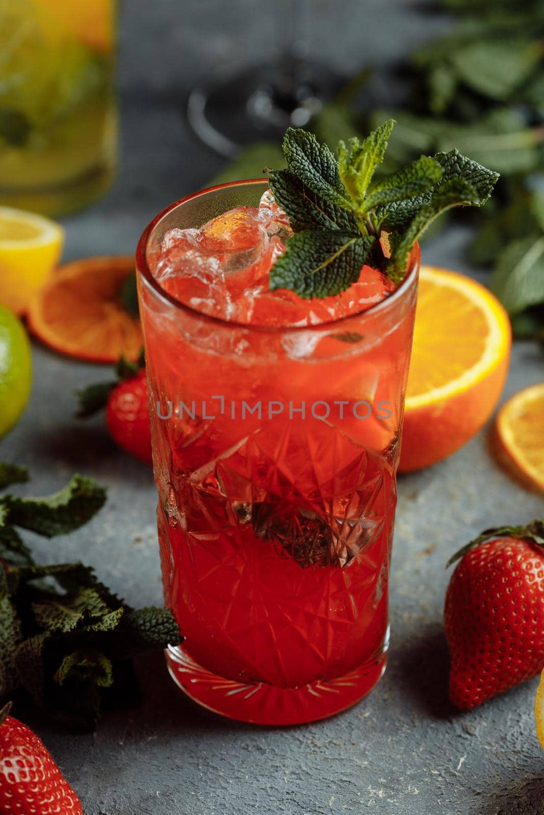 Colorful refreshing drinks for summer, cold strawberry lemonade juice with ice cubes in the glasses garnished with sliced fresh lemons by UcheaD