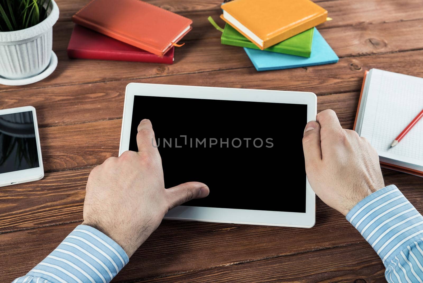 close-up of men's hands with a computer tablet. Businessman works in the office