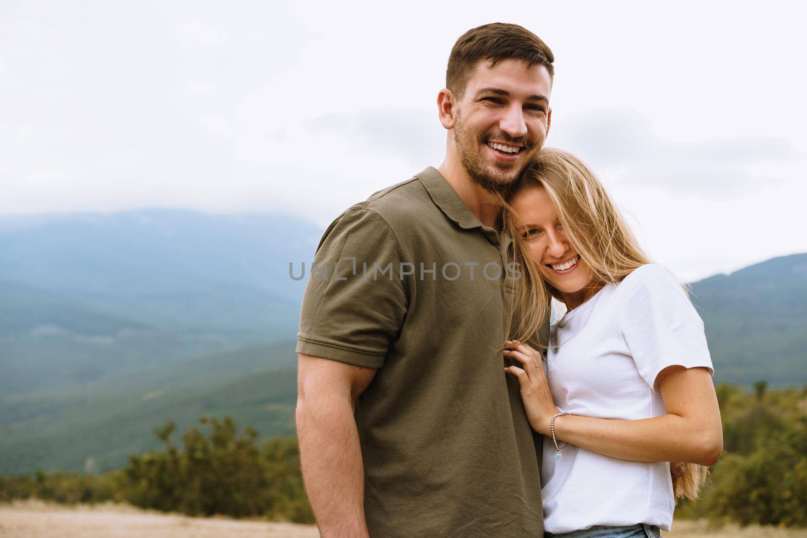 Happy loving couple hiking and hugging in mountains, close up