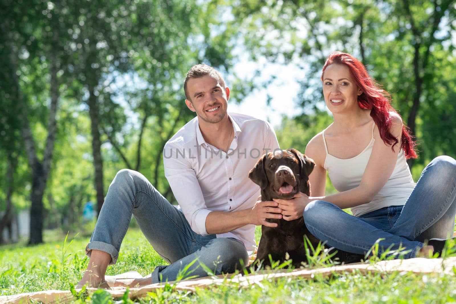 A couple and their dog in the park. Spending time with friends