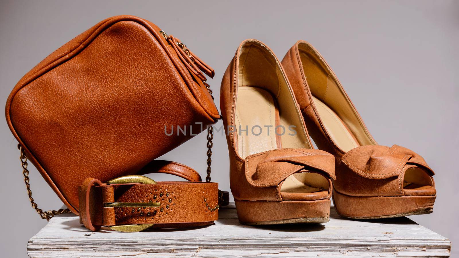 brown female bag with shoes and belt isolated on gray background