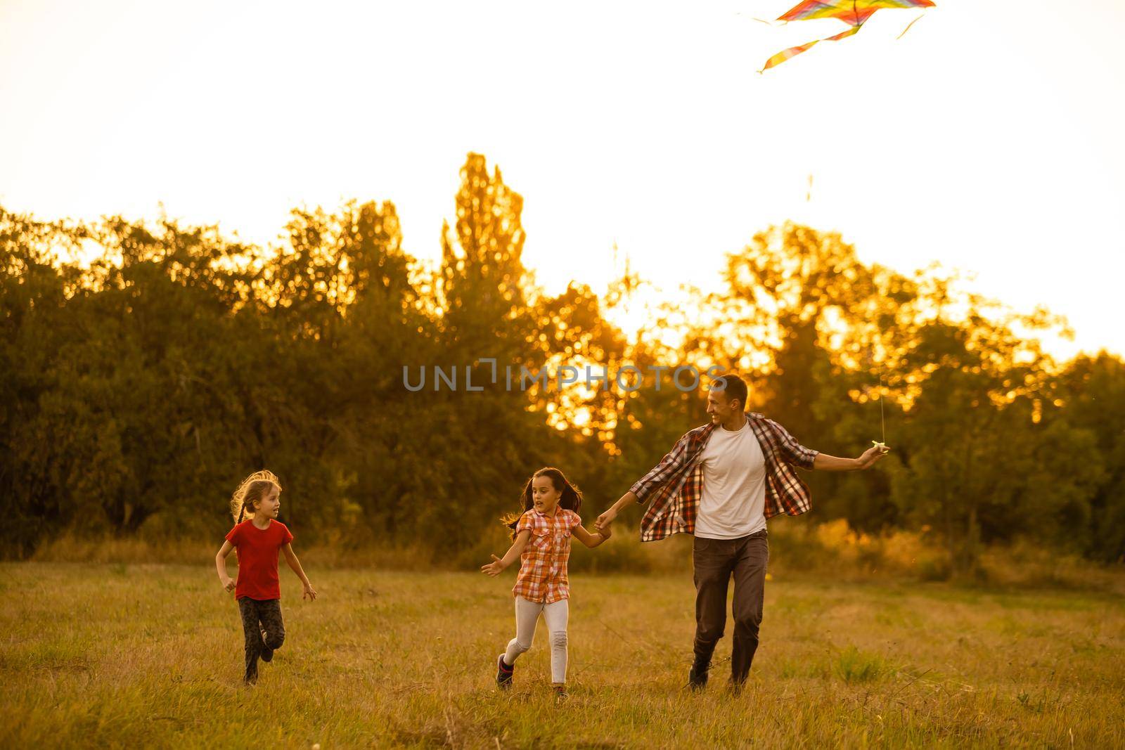 happy family father and child daughter run with a kite on meadow