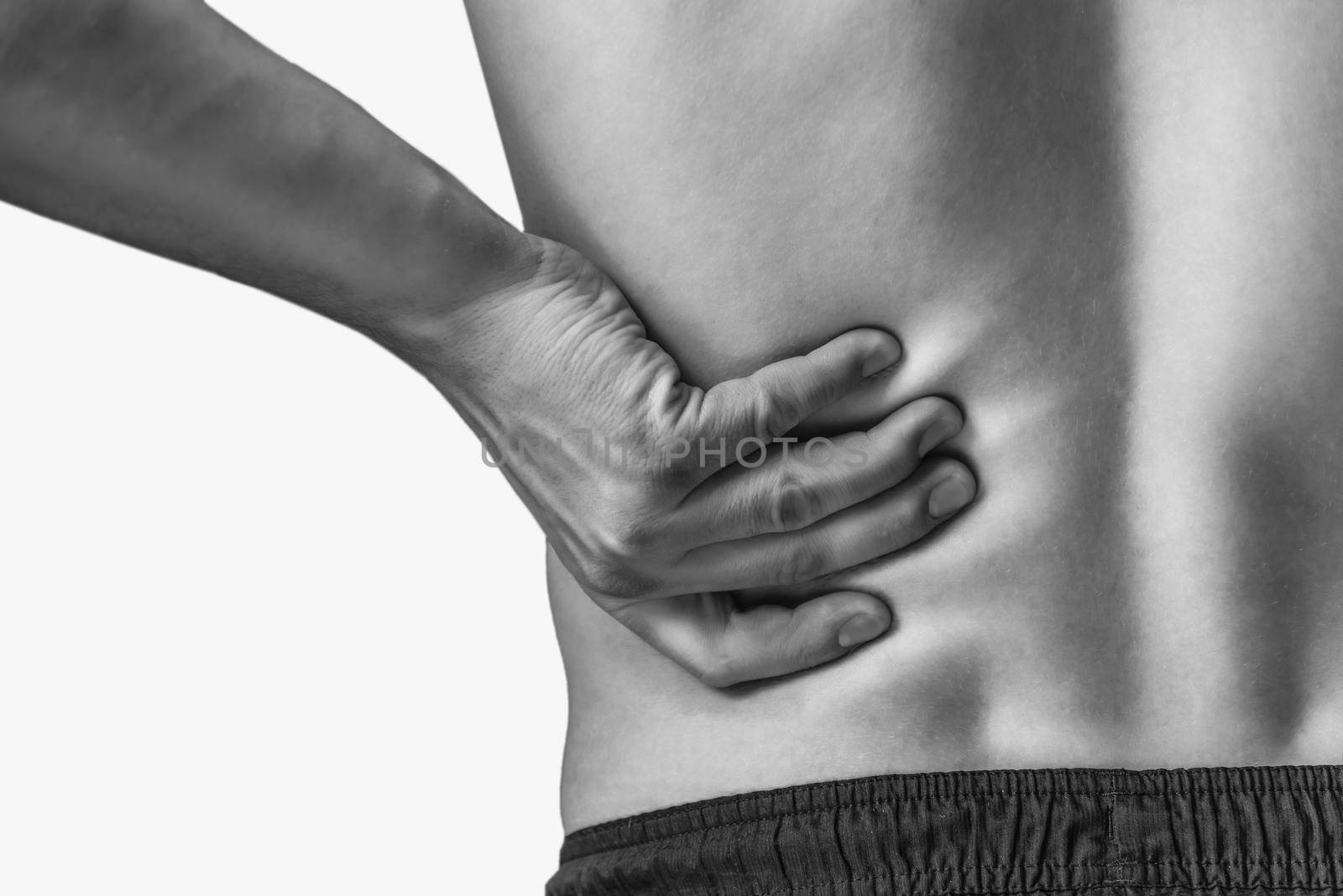 Man touches the lower back, pain in the kidney. Monochrome image, isolated on a white background