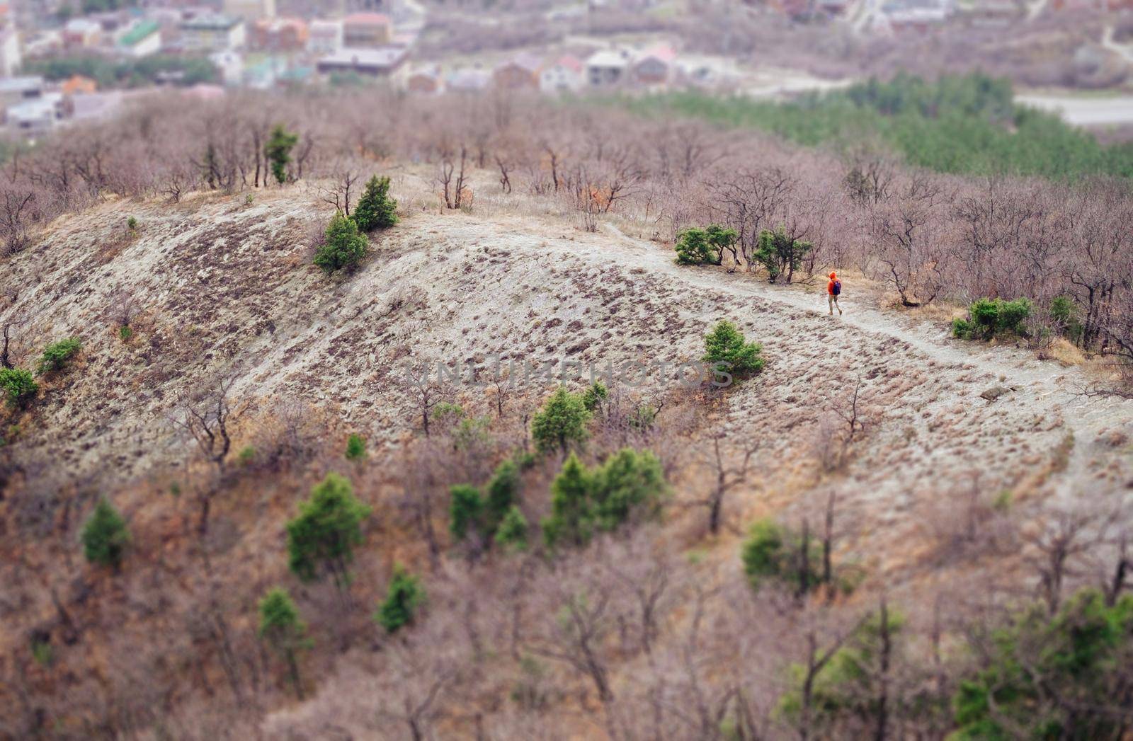 Hiker man walking on path outdoor. Concept minimal person in massive landscape