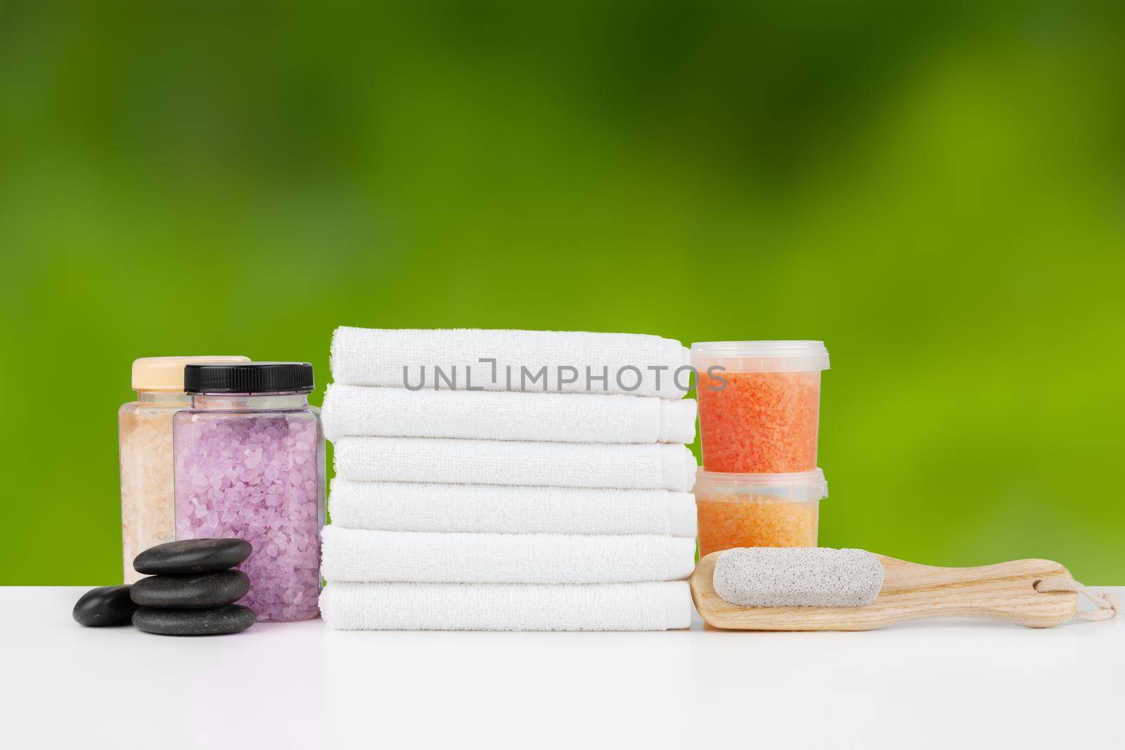 Various spa beauty threatment products and towels against blurred background by Fabrikasimf