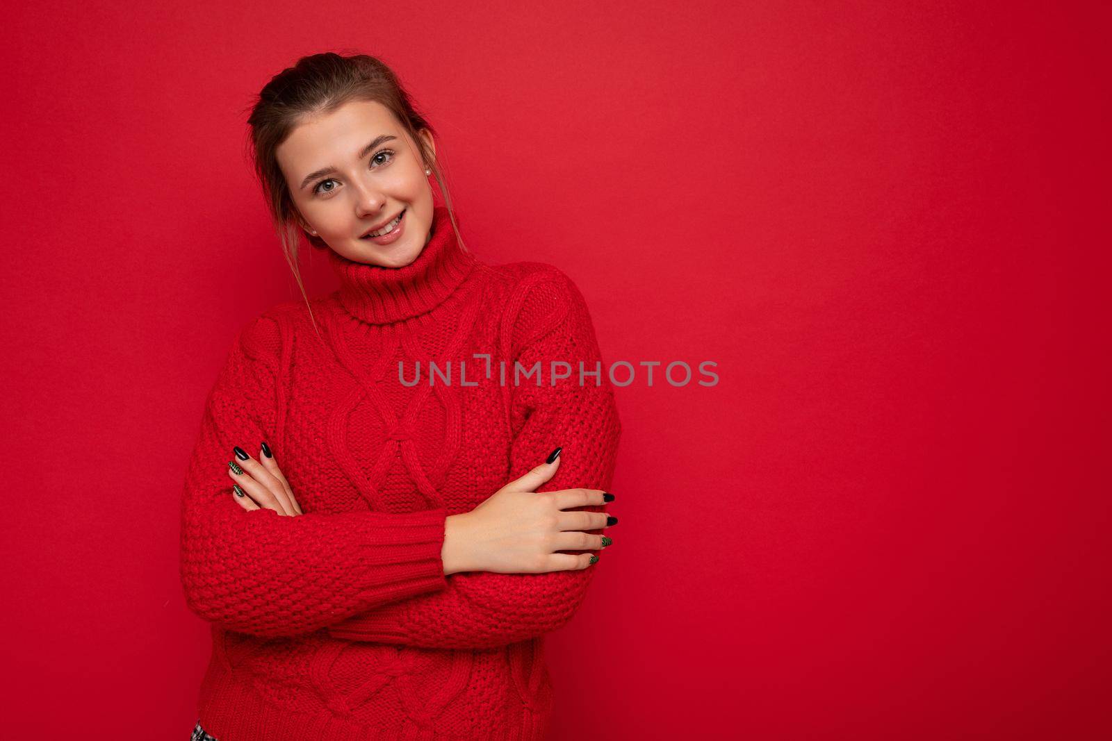 Young happy smiling attractive brunette woman with sincere emotions isolated on background wall with copy space wearing casual red sweater. Positive concept.