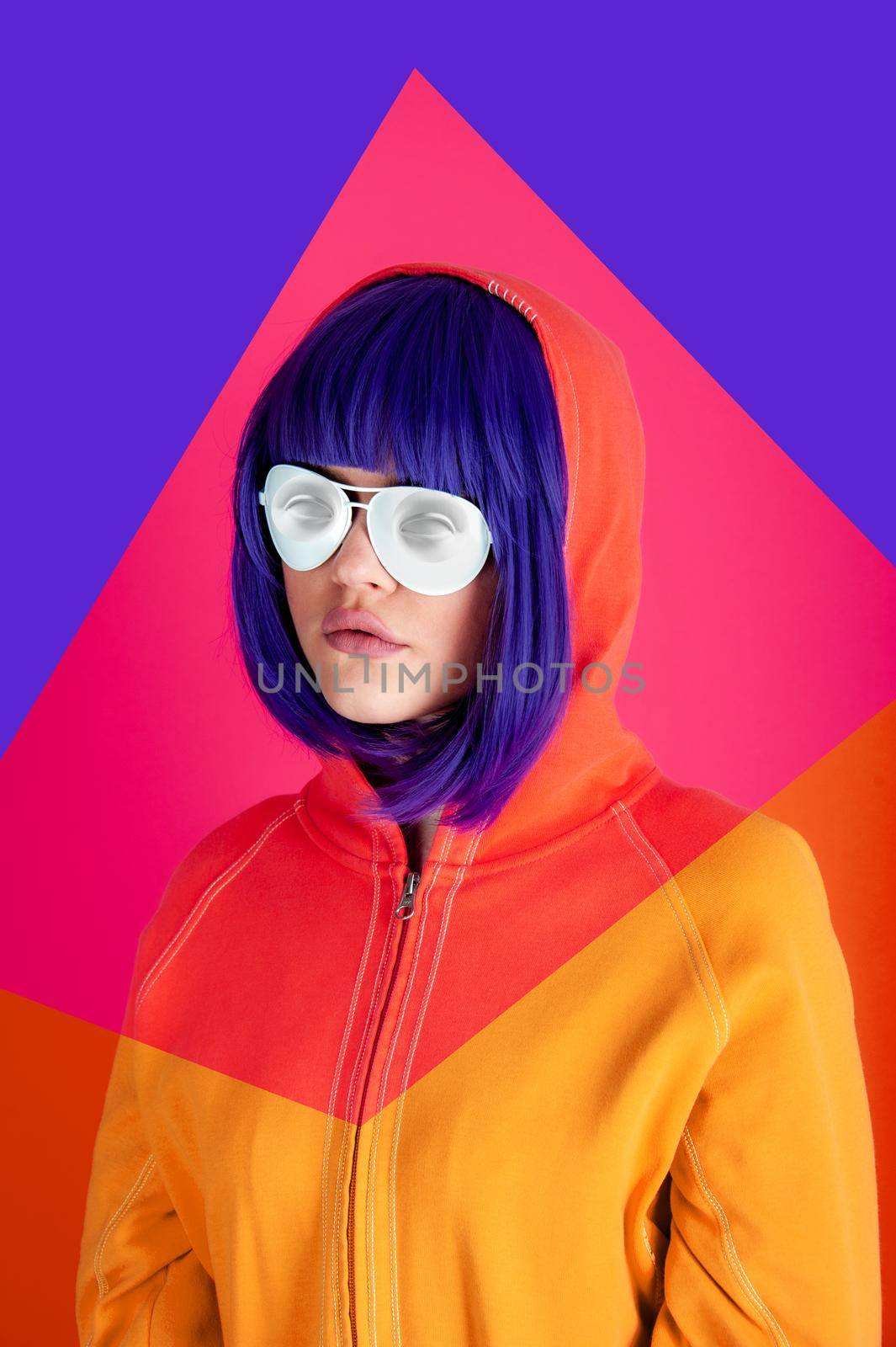 Art collage with alternative funky girl with blue hair on bright blue purple pink background. Close up fashion portrait young beautiful woman in hoodie and white glasses. Unusual youth fashion concept by bashta
