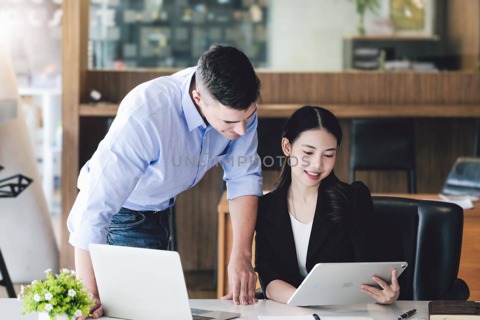 The male marketing manager expressed his satisfaction in selling the company's products. where team members show sales from their iPad screen