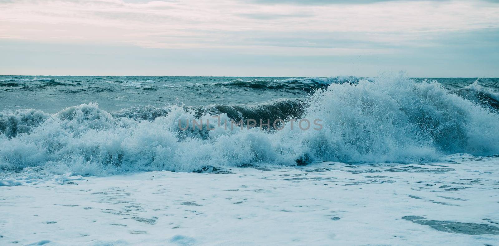 Beautiful sea waves with foam and blue sky, front view