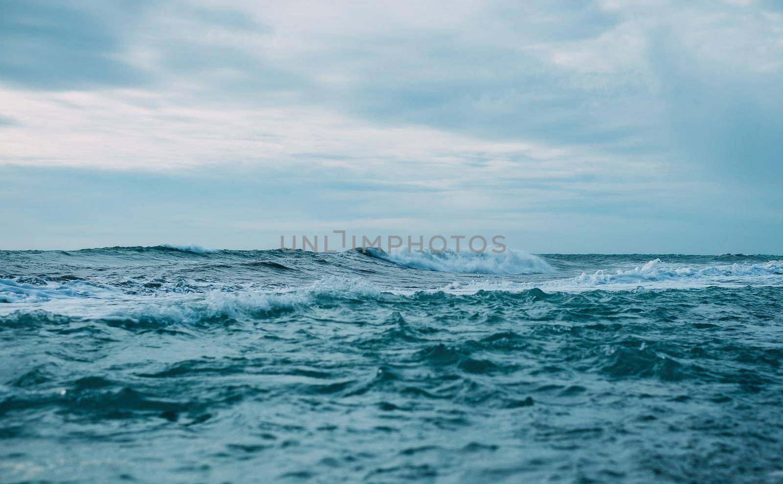 Beautiful sea waves and blue sky with clouds, front view