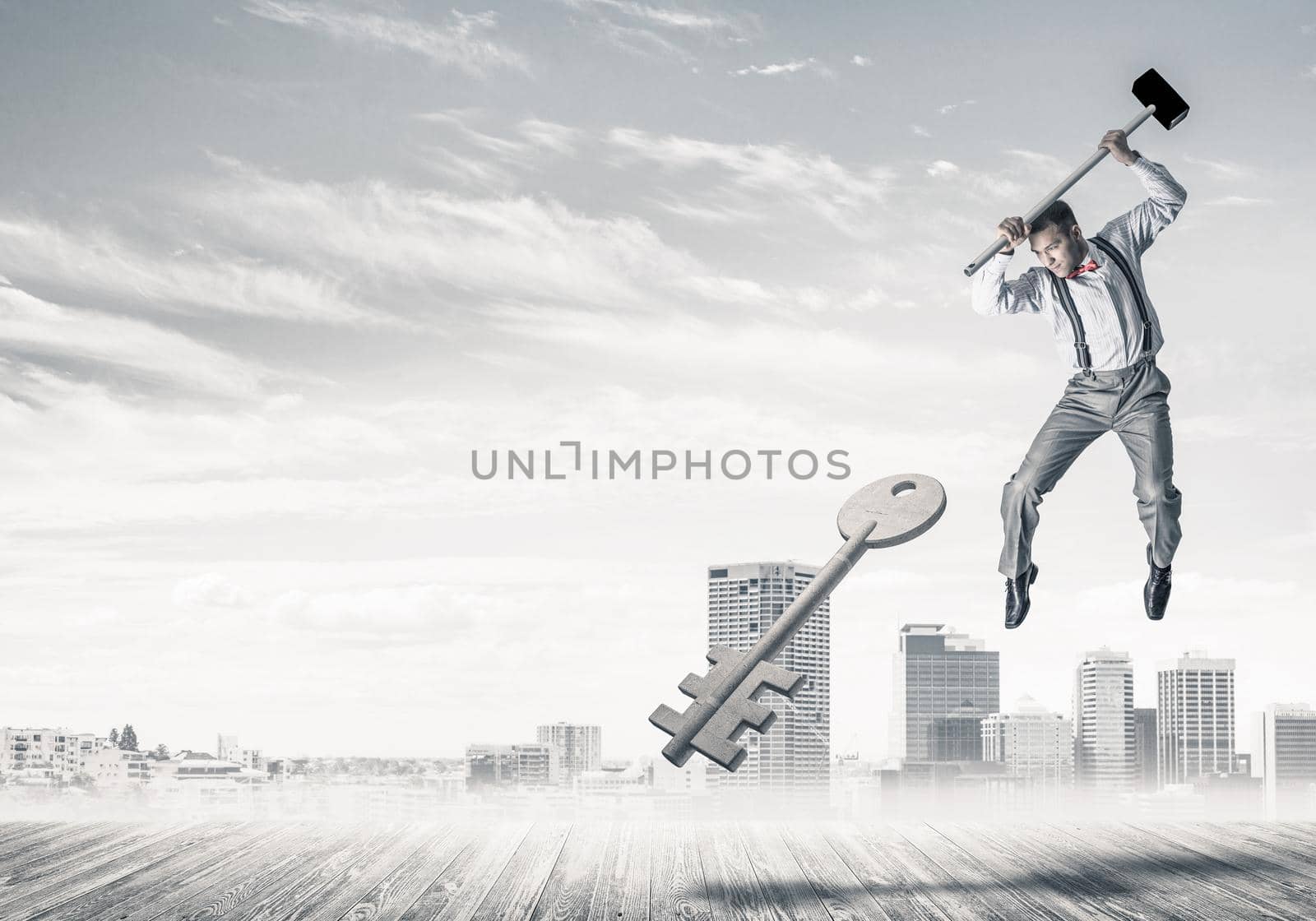 Determined businessman against cityscape breaking with hammer stone key figure