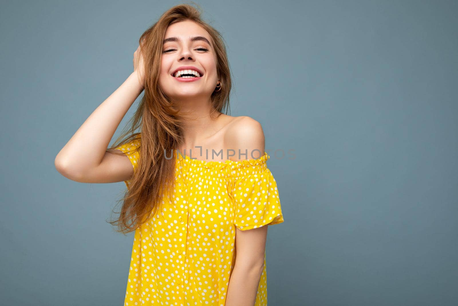 Photo shot of pretty joyful smiling young female person wearing casual trendy outfit standing isolated on colourful background with copy space looking at camera and having fun.