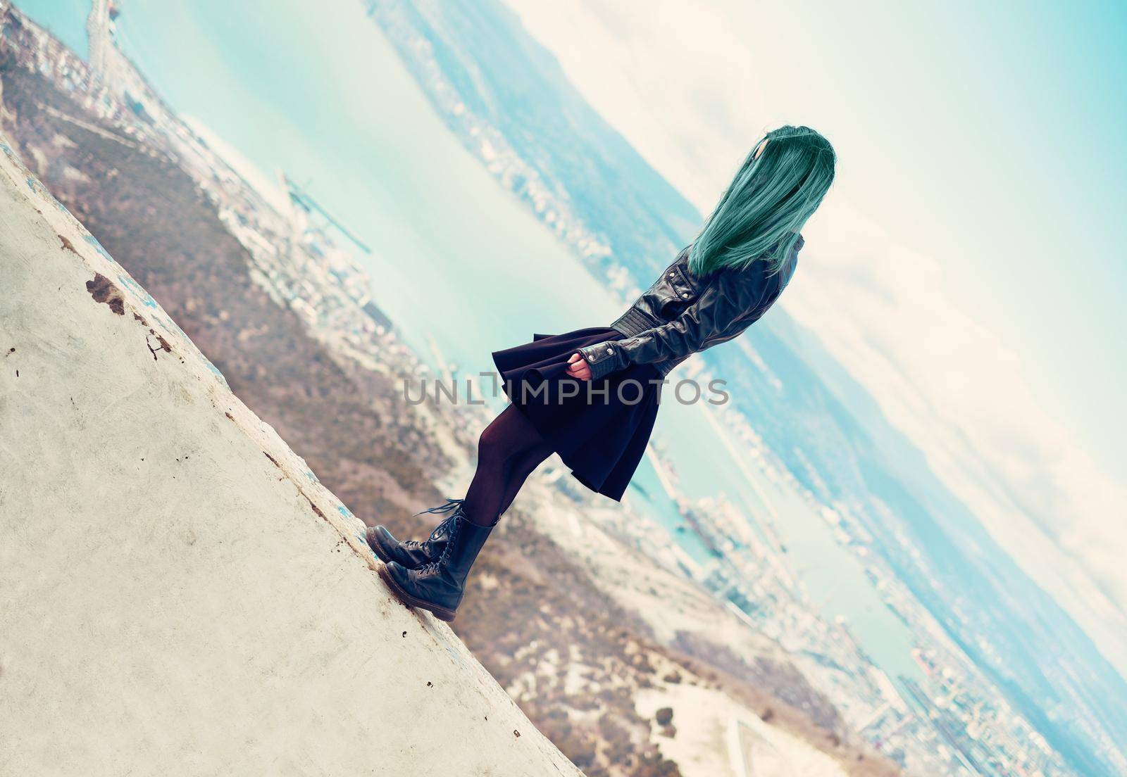 Fashionable beautiful young woman standing on edge over the sea bay outdoor