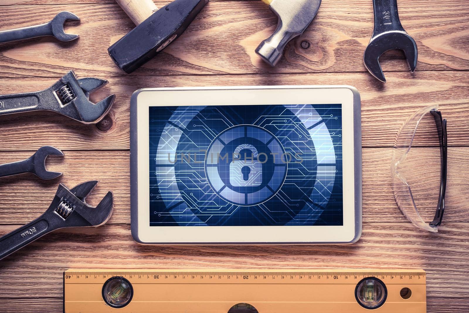 Tablet pc with security concept on screen and industrial tools around