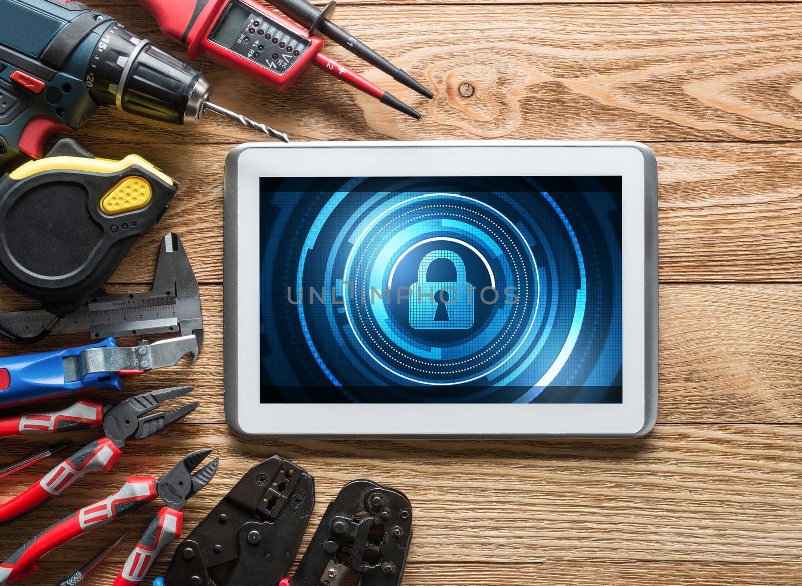 Tablet pc with security concept on screen and industrial tools around