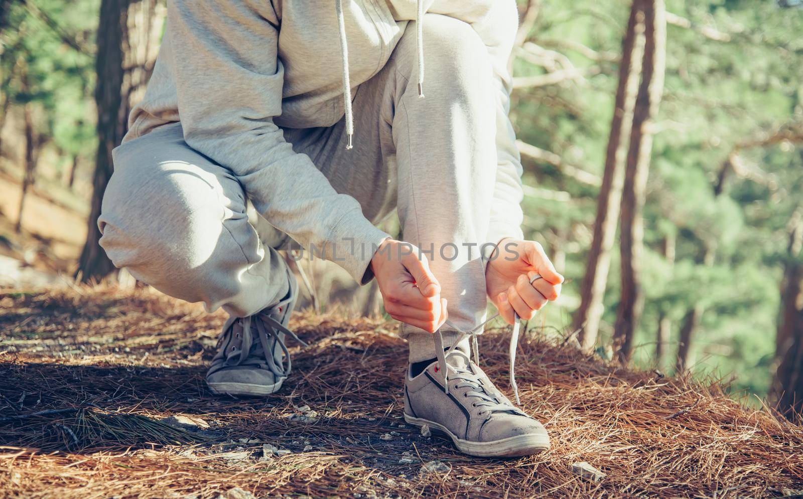 Sportsman tying shoelaces outdoor by alexAleksei