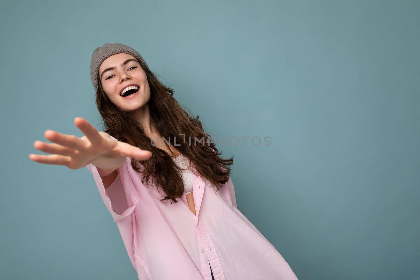 Beautiful positive happy young dark brunette woman isolated over colourful background wall wearing casual stylish clothes feeling sincere emotions looking at camera. Copy space