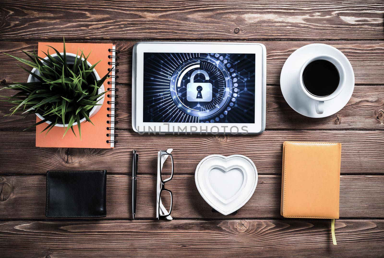Business workplace with office stuff and tablet with padlock icons on screen