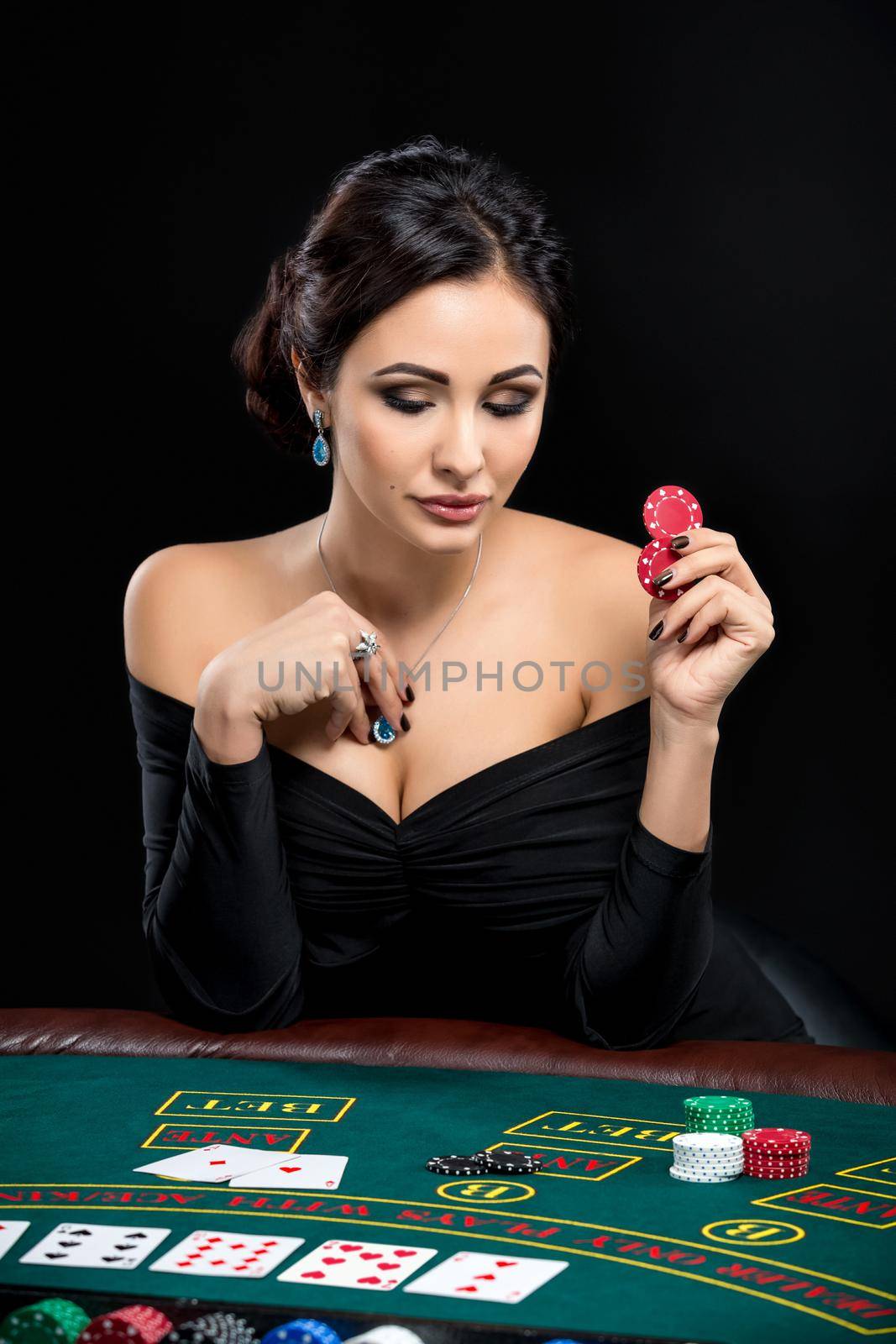 sexy woman with poker cards and chips. Female player in a beautiful black dress