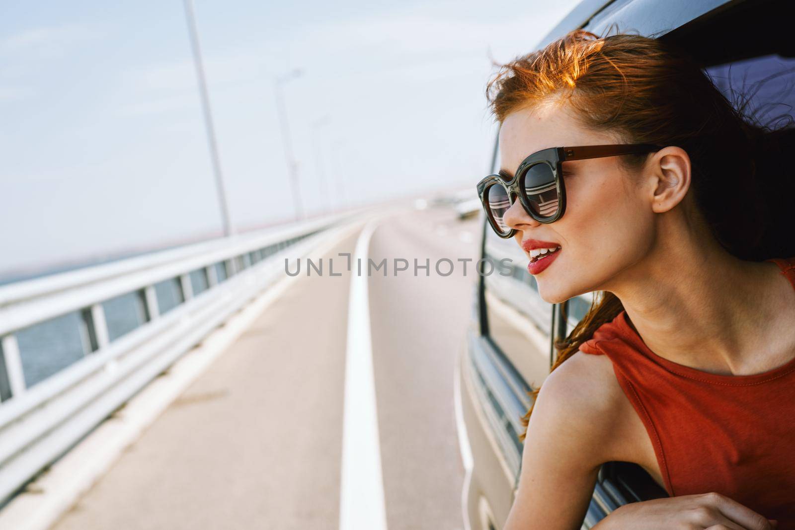 woman looking out of car window wearing sunglasses travel lifestyle by Vichizh