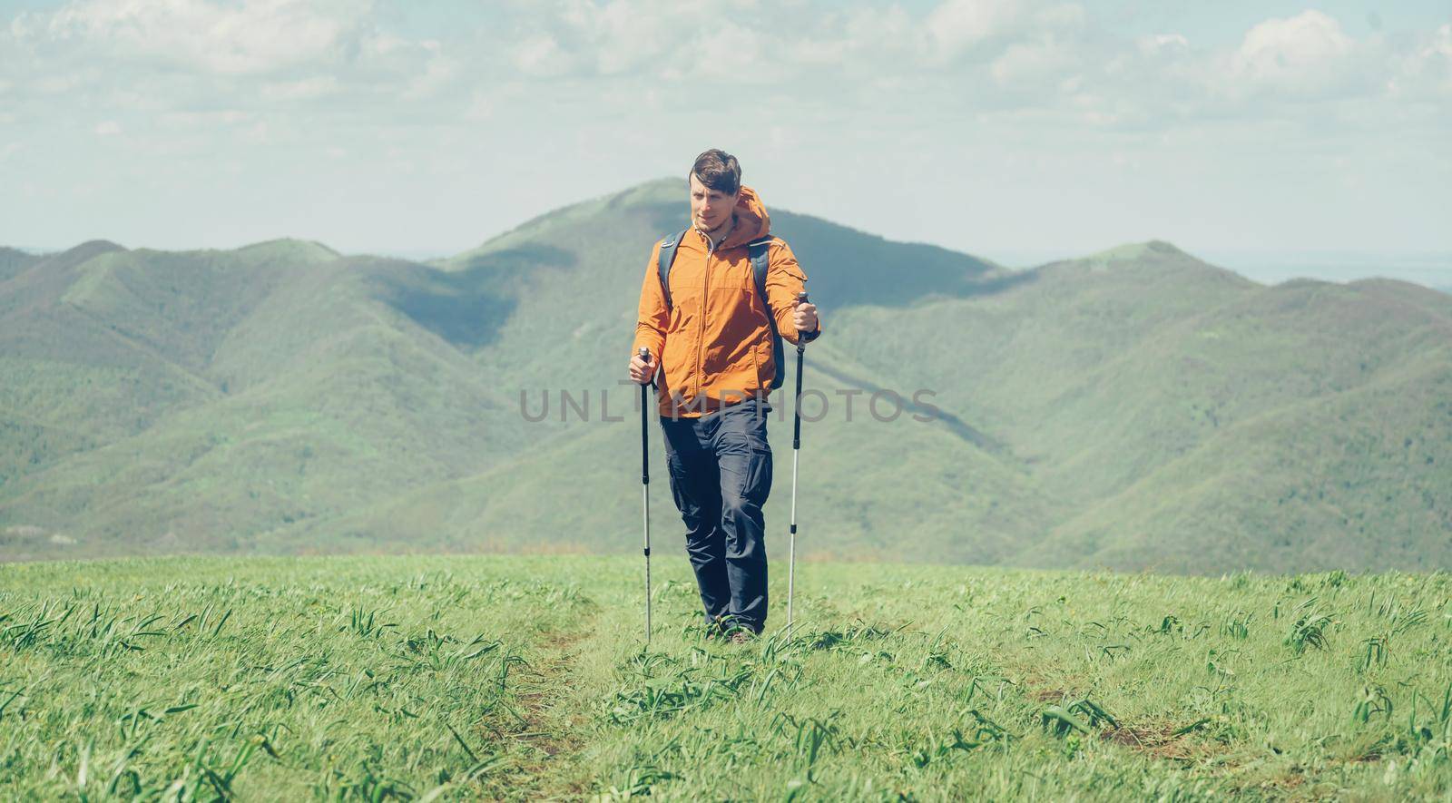 Hiker man walking in the mountains by alexAleksei