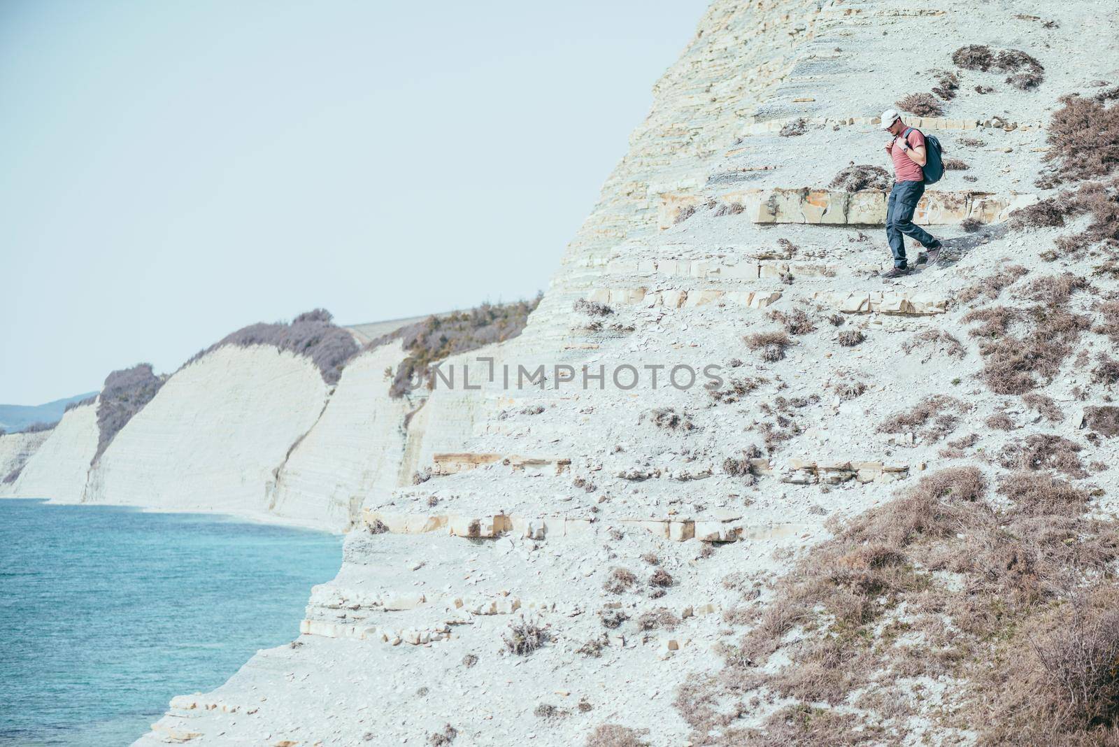 Man go down on steep coast by alexAleksei