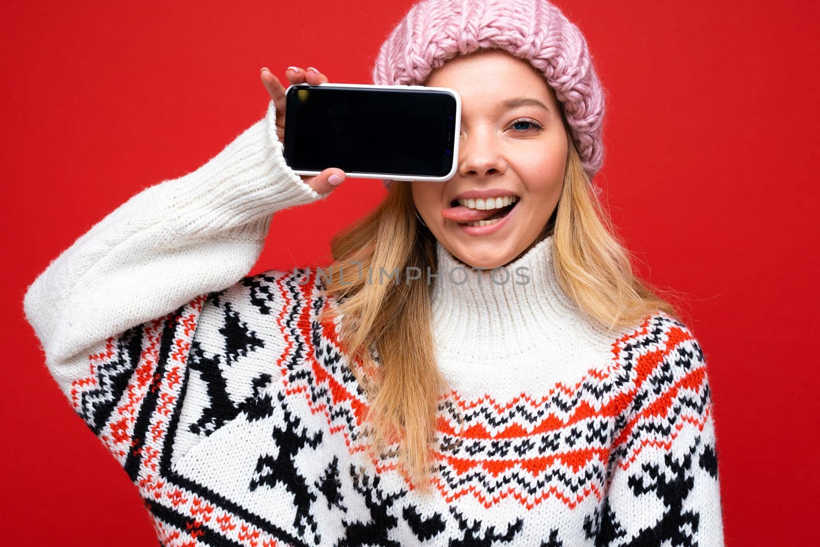 Image of a shocked young beautiful woman posing isolated over red wall background play games by mobile phone. by TRMK