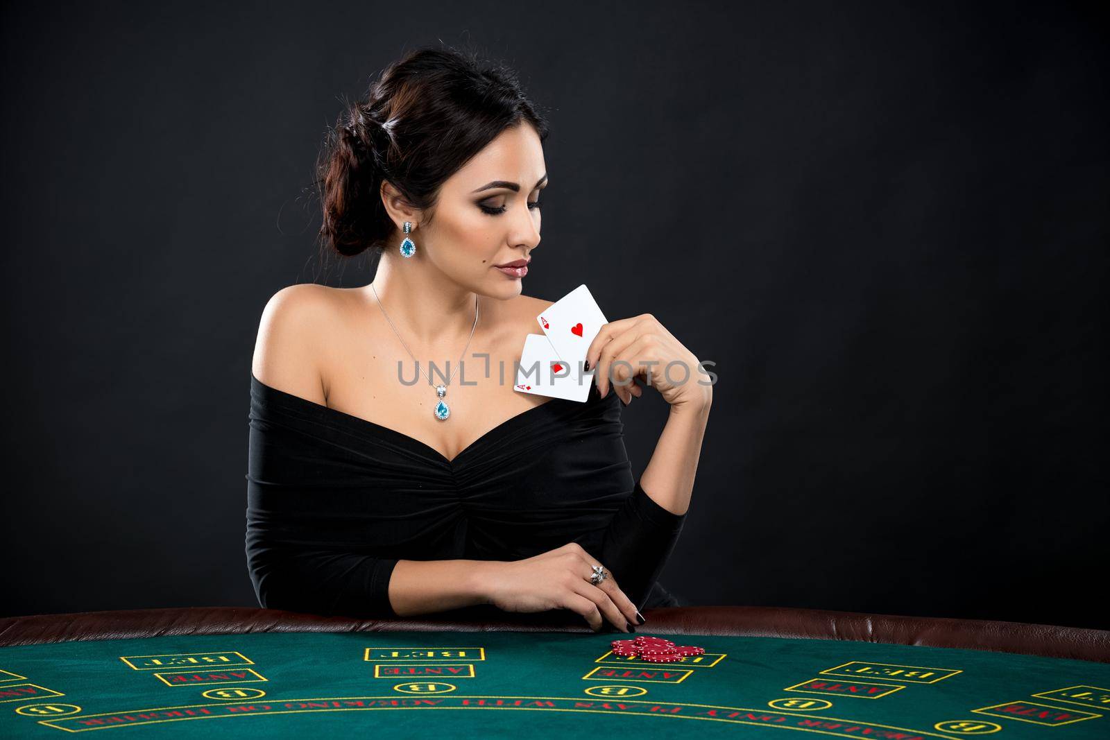 sexy woman with poker cards and chips. Female player in a beautiful black dress