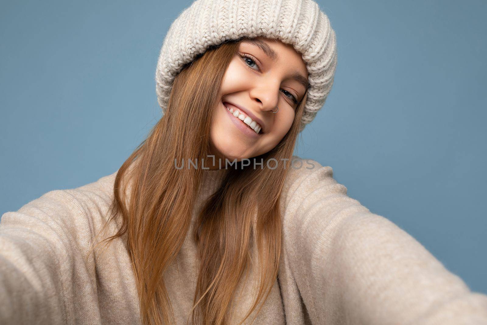 Closeup photo of attractive sexy happy smiling young dark blonde woman standing isolated over colourful background wall wearing everyday trendy clothes looking at camera showing facial emotions.