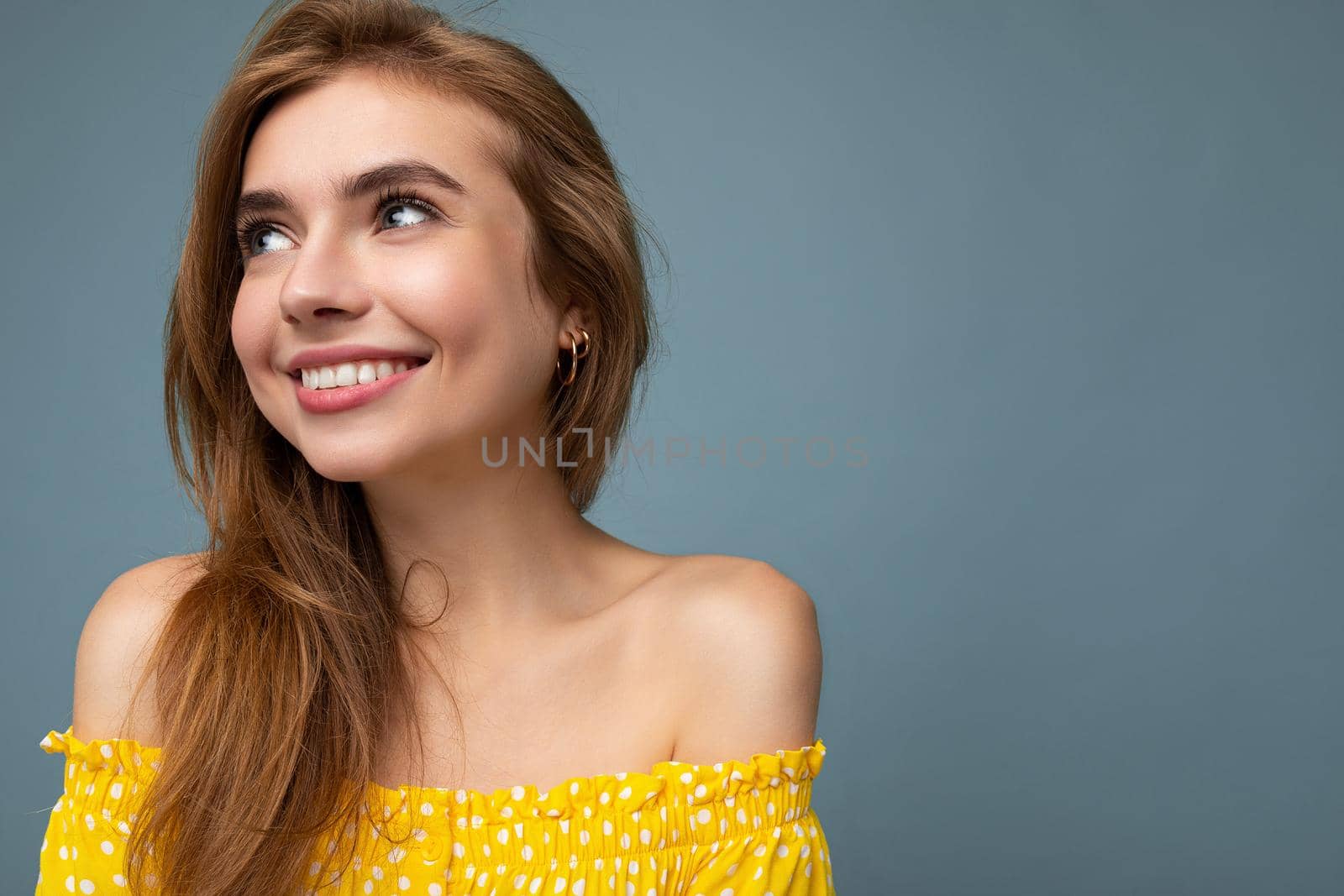 Closeup photo of young cute beautiful dark blonde woman with sincere emotions isolated on background wall with copy space wearing stylish summer yellow dress. Positive concept.