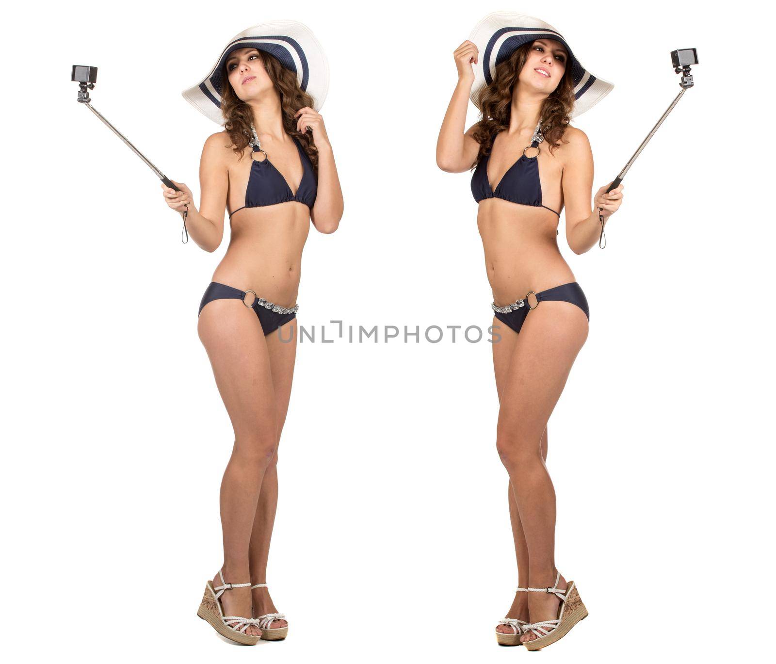 Travel concept. Studio portrait of pretty young woman taking selfie with action camera. Isolated on white.