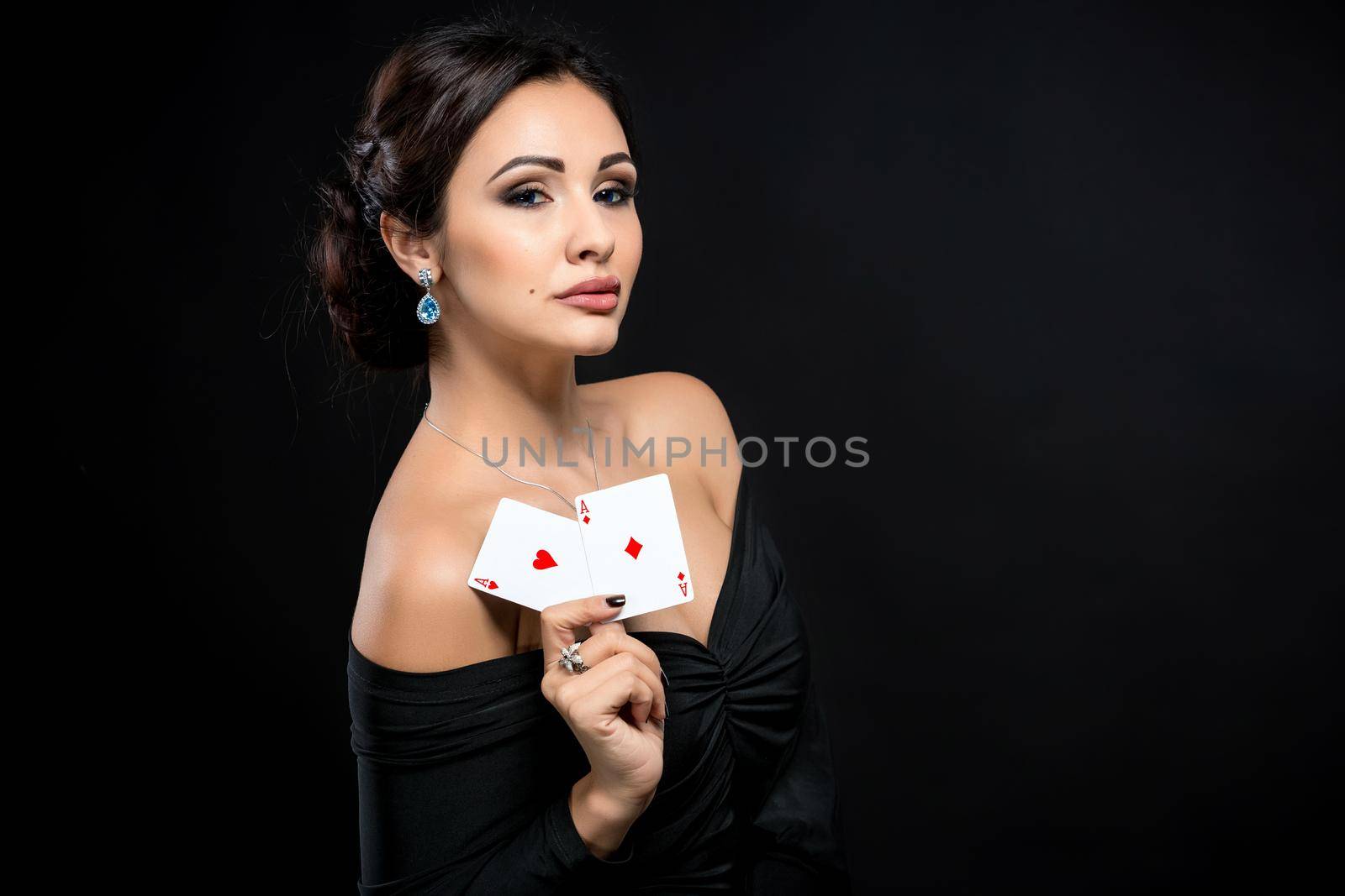 sexy woman with poker cards. Female player in a beautiful black dress
