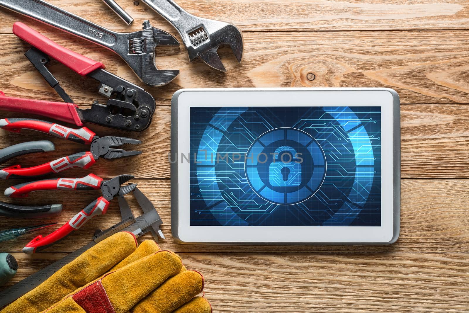 Tablet pc with security concept on screen and industrial tools around