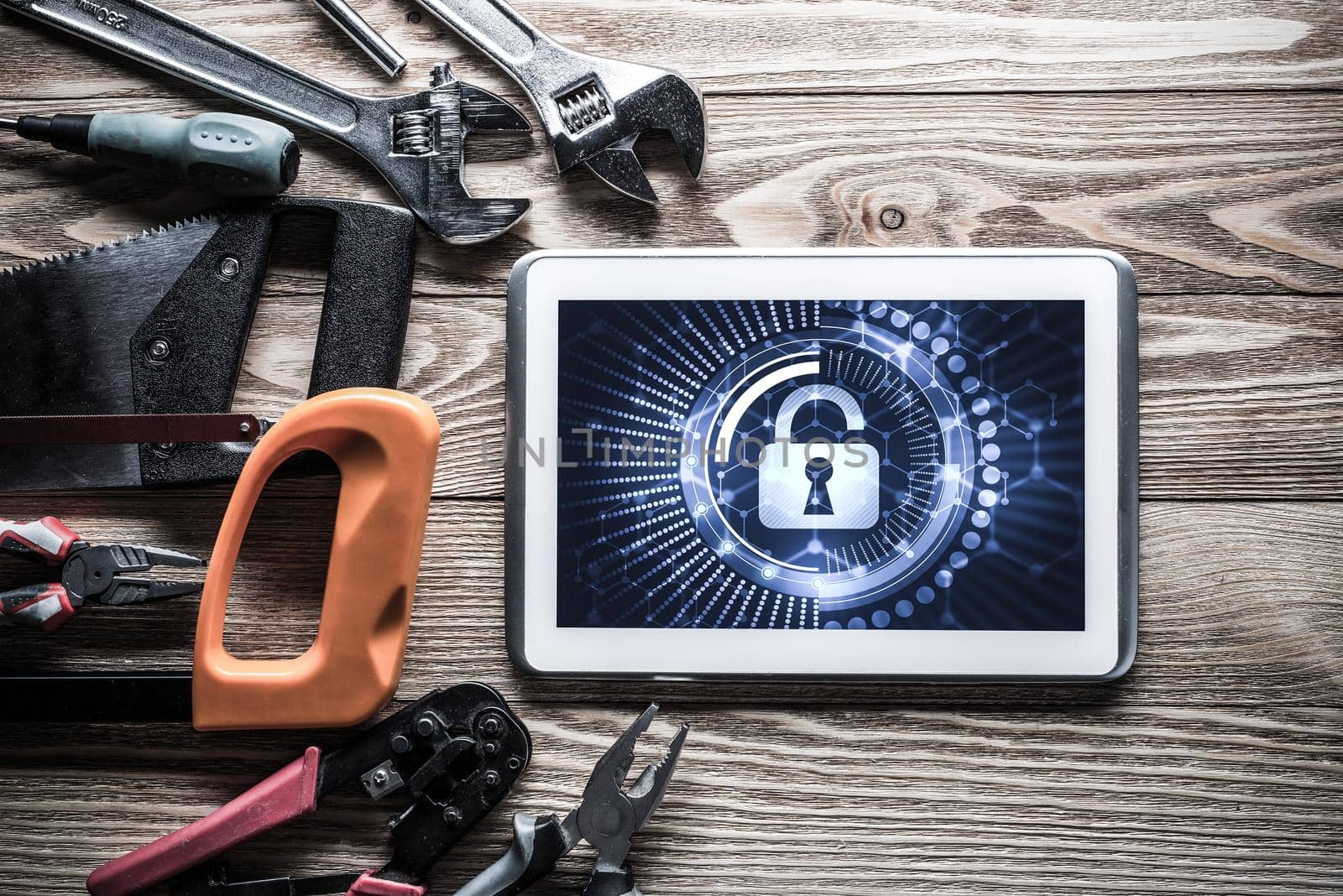Tablet pc with security concept on screen and industrial tools around
