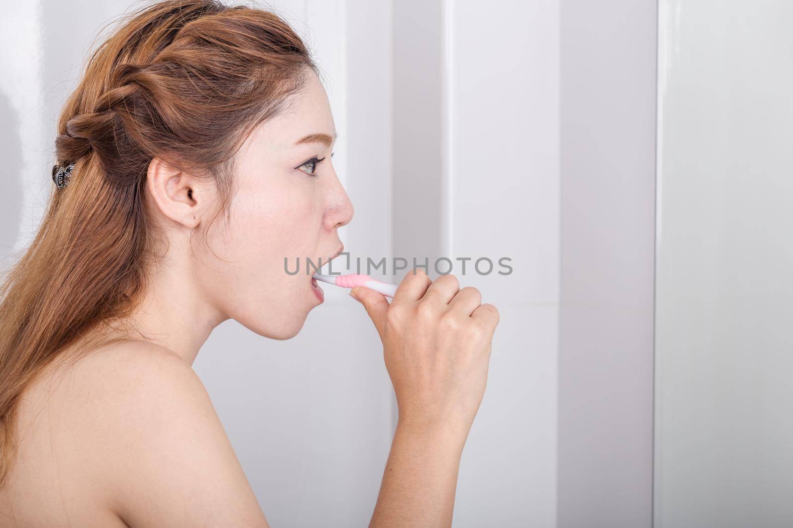 woman brushing teeth in the bathroom