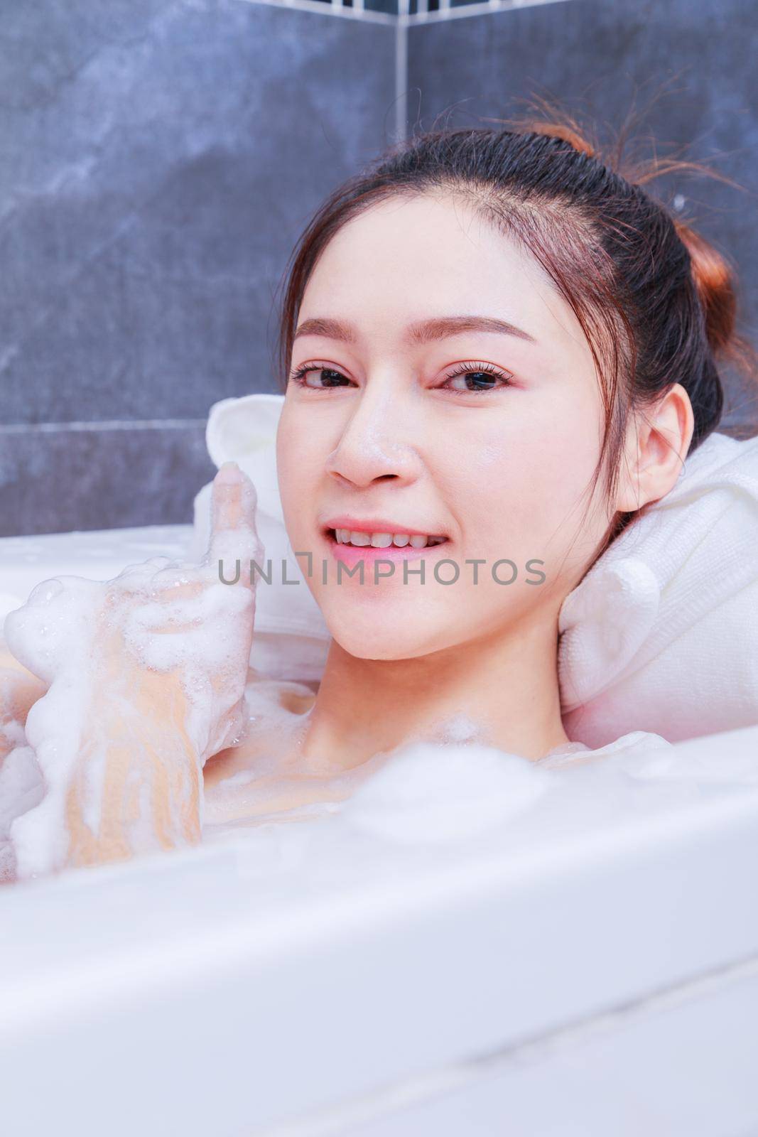 woman relaxing in the bathtub in the bathroom by geargodz