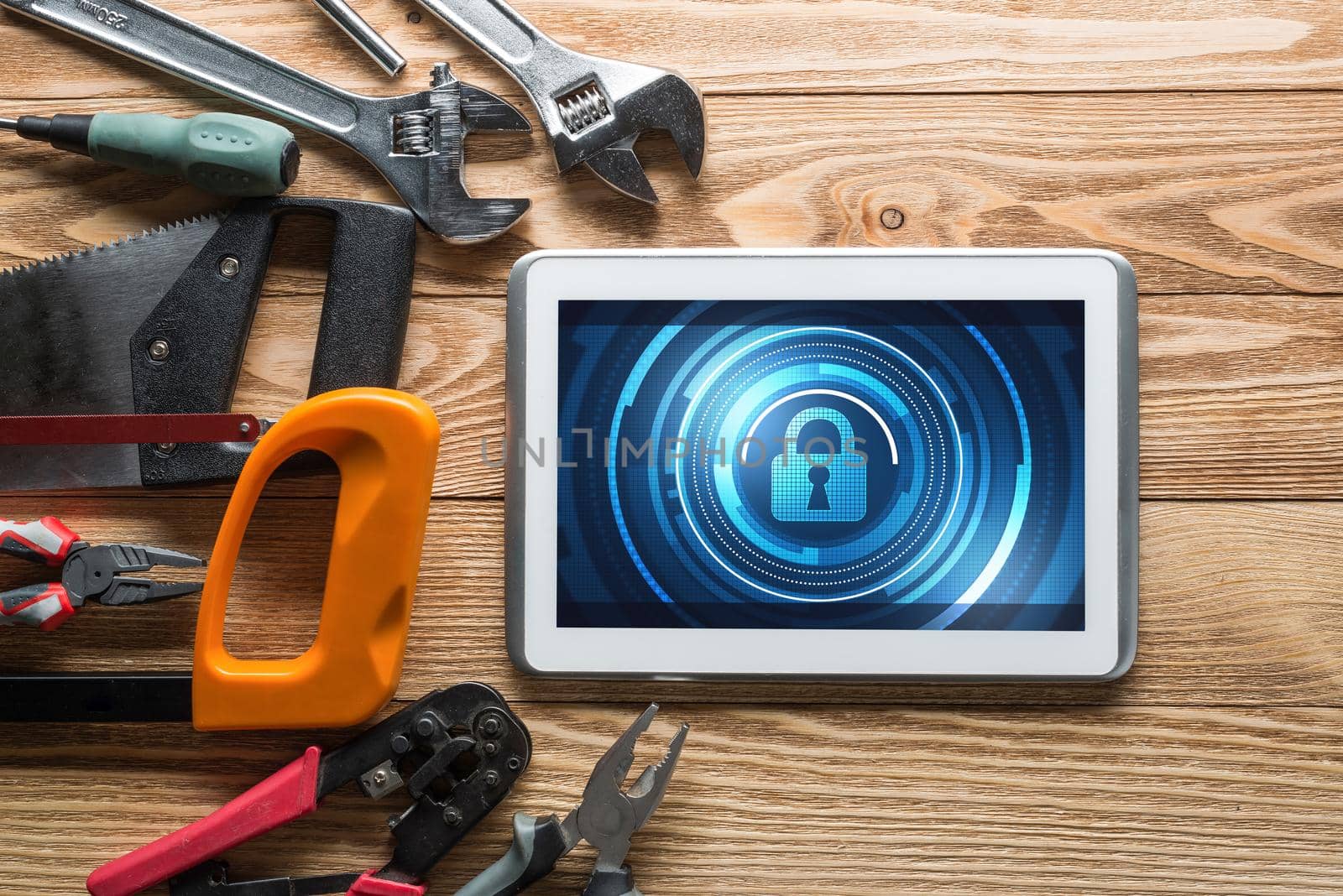 Tablet pc with security concept on screen and industrial tools around